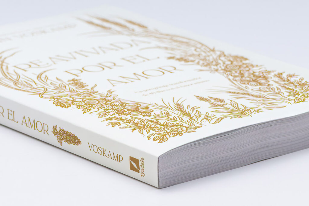 Perfect bound book with white cover and gold foil design, showing clean squared spine and page block demonstrating professional binding construction.