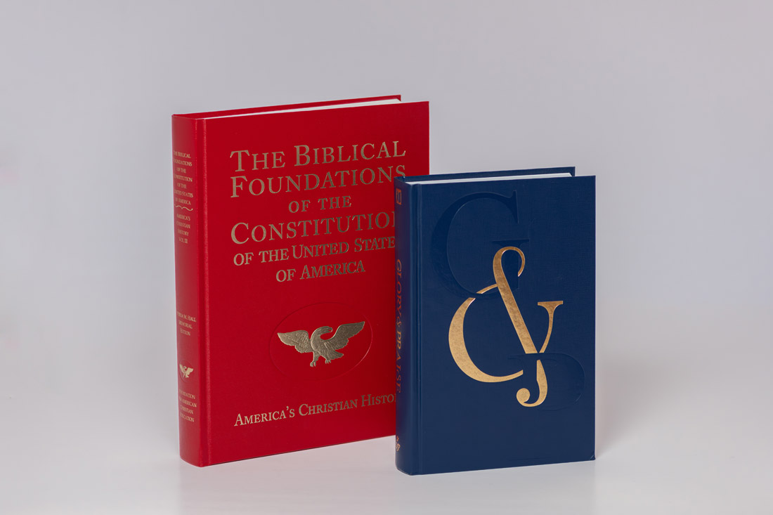 Two hardcover books displayed together: red book titled 'The Biblical Foundations of the Constitution of the United States of America' with eagle emblem, and navy blue book with gold ampersand symbol.